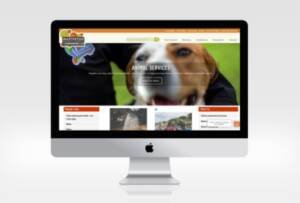iMac screen sdisplaying the4 homepage of Masterton District Council website featuring a close-up photo of a dog smiling.